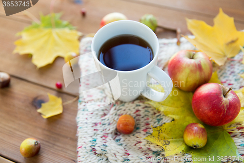 Image of close up of tea cup on table with autumn leaves