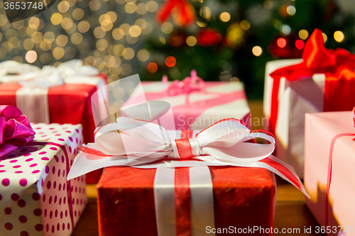 Image of close up of gift boxes over christmas tree lights