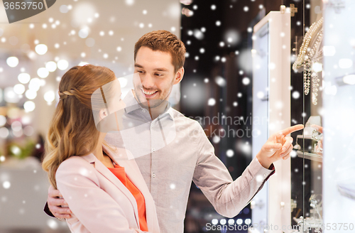 Image of couple looking to shopping window at jewelry store