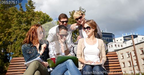 Image of group of happy students with notebooks at campus