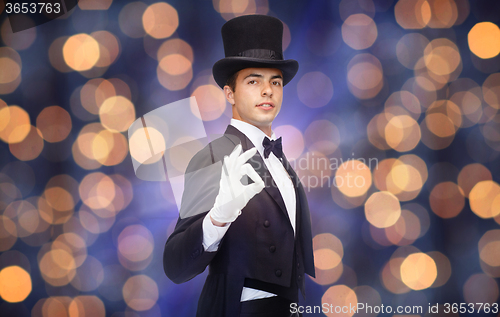 Image of magician in top hat showing ok hand sign