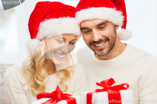 Image of happy couple at home with christmas gift boxes