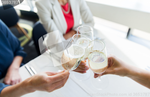 Image of close up of women clinking champagne at restaurant