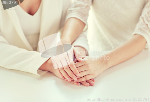 Image of close up of happy married lesbian couple hands