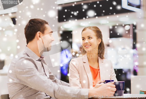 Image of happy couple with shopping bags drinking coffee