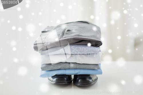 Image of close up of male shirts, pants and shoes on table