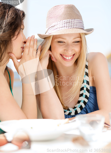 Image of girls gossiping in cafe on the beach