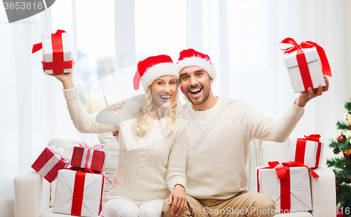 Image of happy couple at home with christmas gift boxes