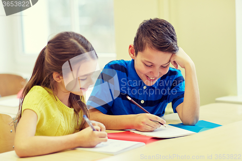 Image of group of school kids writing test in classroom