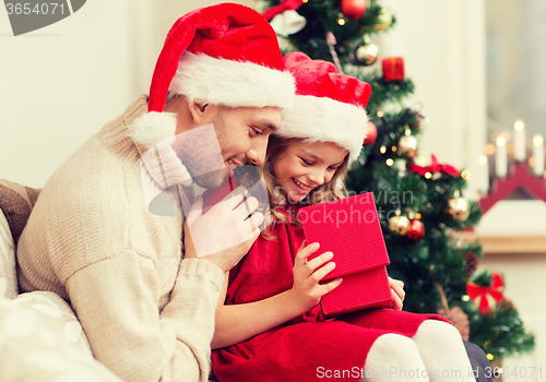 Image of smiling father and daughter opening gift box