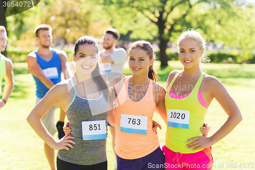 Image of happy young sporty women with racing badge numbers