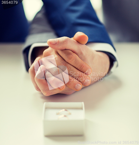 Image of close up of male gay couple and wedding rings