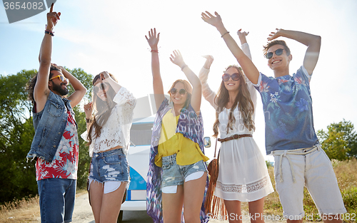 Image of happy young hippie friends dancing outdoors