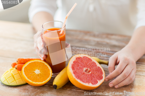 Image of close up of woman hands with juice and fruits