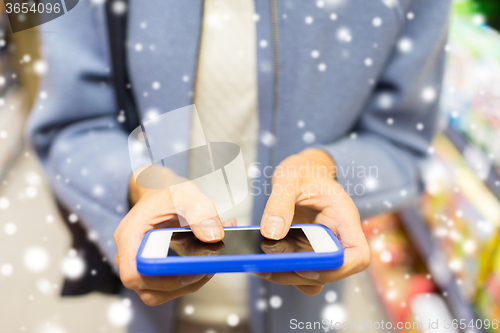 Image of close up of woman with smartphone in market