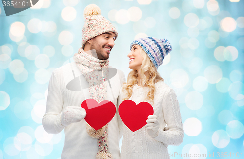 Image of smiling couple in winter clothes with red hearts