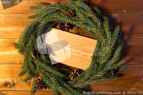 Image of natural green fir branch wreath and wooden board