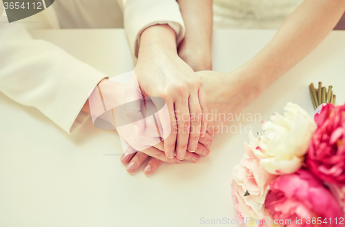 Image of close up of happy married lesbian couple hands