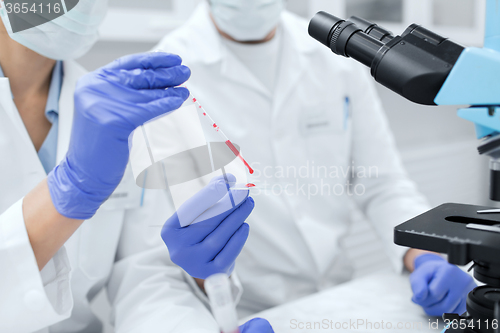 Image of close up of scientists filling perti dish in lab