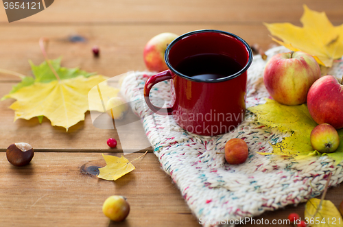 Image of close up of tea cup on table with autumn leaves