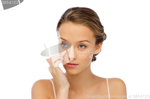 Image of young woman applying cream to her face