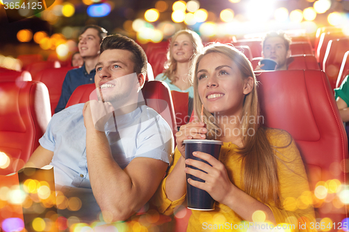 Image of happy friends watching movie in theater