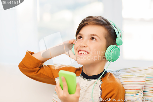 Image of happy boy with smartphone and headphones at home