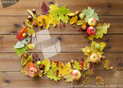 Image of set of autumn leaves, fruits and berries on wood