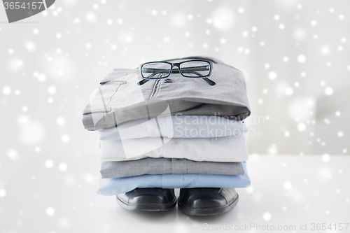 Image of close up of folded male shirts and shoes on table