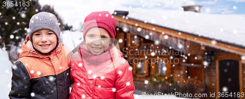Image of happy girl hugging boy over country house and snow