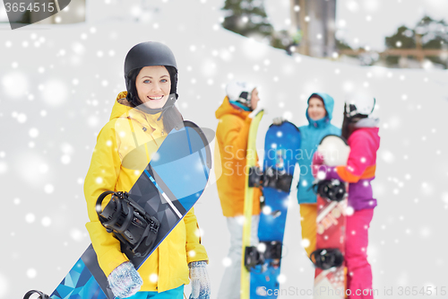 Image of happy friends in helmets with snowboards