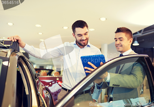 Image of happy man with car dealer in auto show or salon