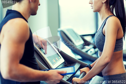 Image of close up of woman with trainer on treadmill in gym