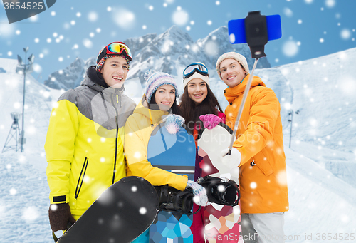 Image of happy friends with snowboards and smartphone