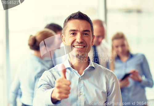 Image of group of smiling businesspeople meeting in office