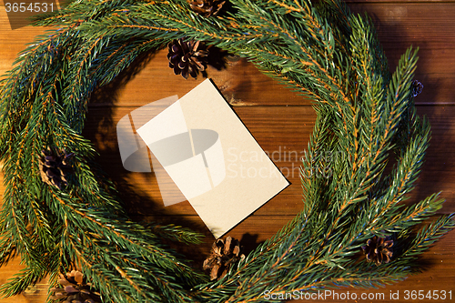 Image of natural green fir wreath with note on wooden board