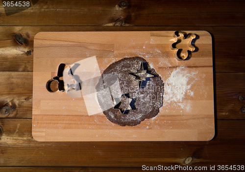 Image of close up of ginger dough, molds and flour on board