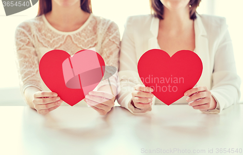 Image of close up of happy lesbian couple with red hearts