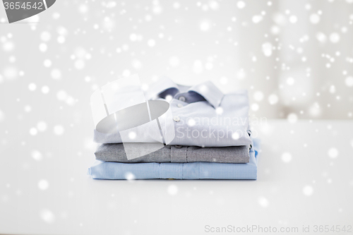 Image of close up of ironed and folded shirts on table