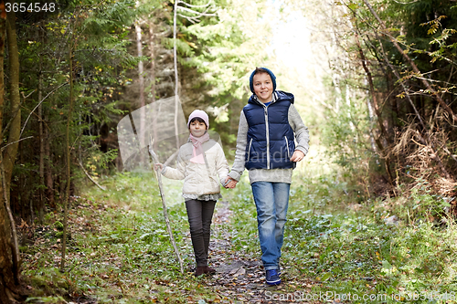 Image of two happy kids walking along forest path