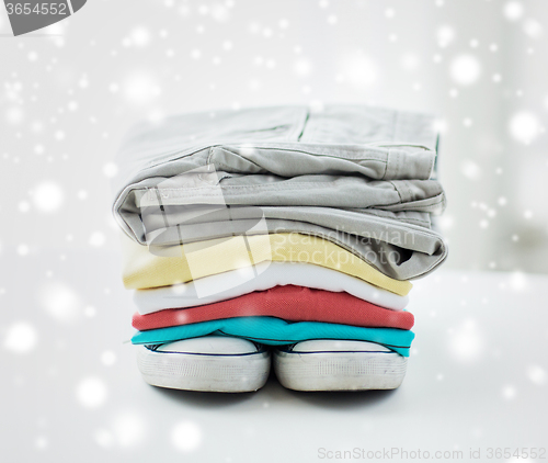 Image of close up of folded shirts and boots on table