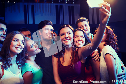 Image of friends with smartphone taking selfie in club