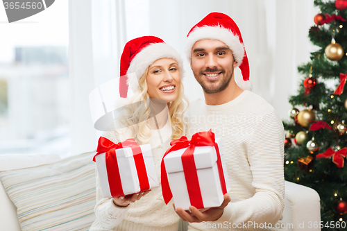 Image of happy couple at home with christmas gift boxes