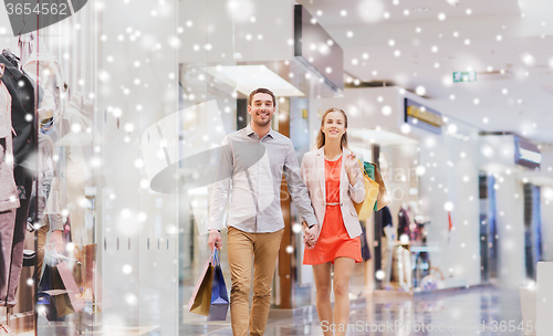 Image of happy young couple with shopping bags in mall