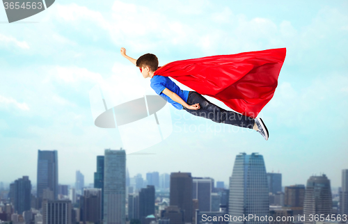 Image of boy in red superhero cape and mask flying on air