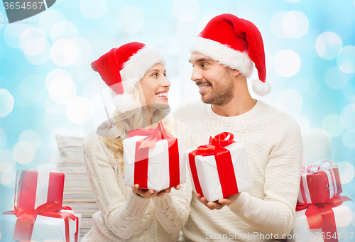 Image of happy couple at home exchanging christmas gifts