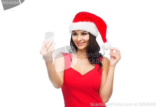 Image of woman in santa hat taking selfie by smartphone