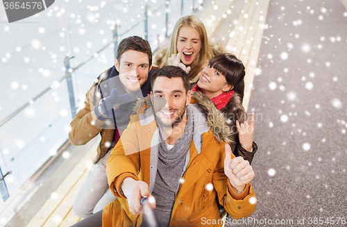 Image of happy friends taking selfie on skating rink