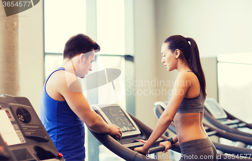 Image of woman with trainer on treadmill in gym