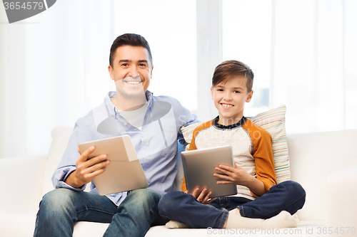 Image of happy father and son with tablet pc at home